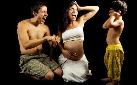 Familia jugando con su hijo mayor en sesión de embarazo