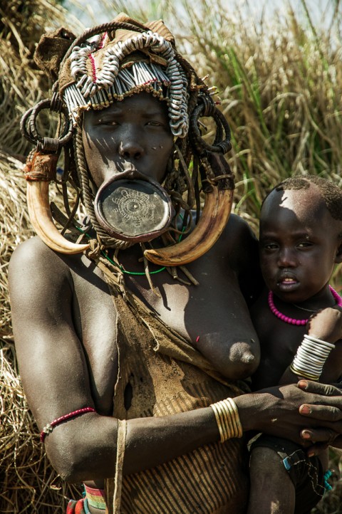 Mujer de la tribu Mursi con hijo y plato en el labio, Etiopía
