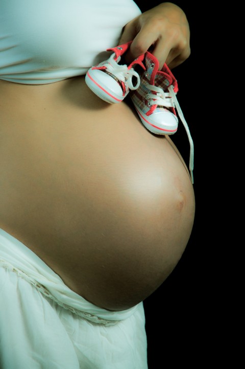 Sesión de embarazo, Madre pone patucos en barriga